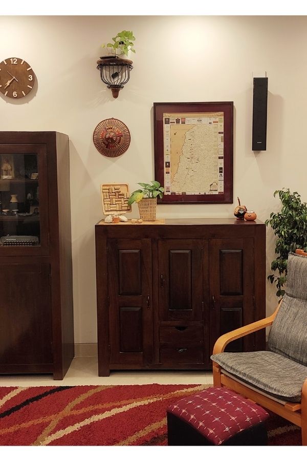 The wooden furniture the poang chair and footstool, hat on the wall, map frame and green plant at the corner of the room | Home Tour: A beautiful Antique Modern home in Bangalore