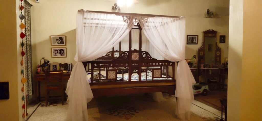 Villa Rashmi - A Heritage Gem in Mumbai | The bedroom was decorated with family frame, wooden dresser and wooden reading desk at the corner of the room | TheKeybunch decor blog