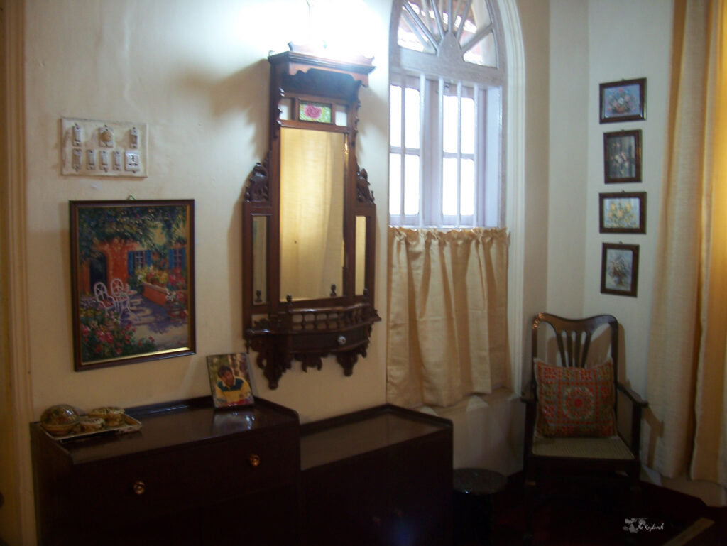 The beautiful wooden mirror with antique cabinet and old cathedral window at the bedroom | Belmont House in Mangalore, India | TheKeybunch decor blog