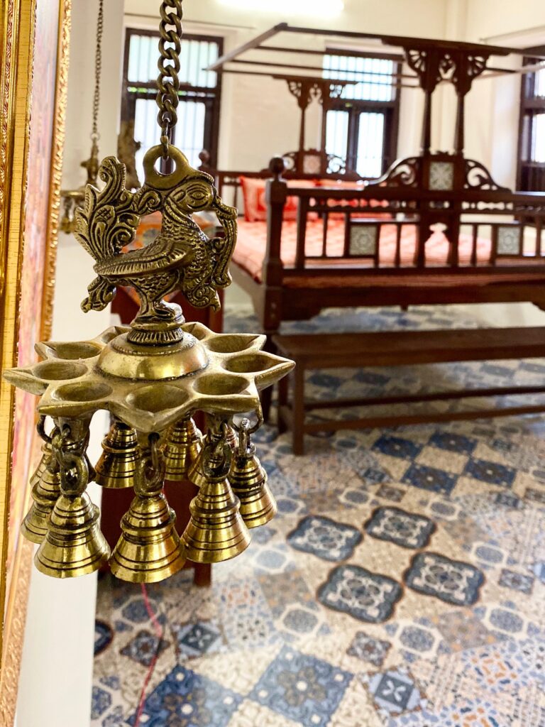 Villa Rashmi - A Heritage Gem in Mumbai | Brass peacock hanging diya lamp at the corner of the bedroom | TheKeybunch decor blog