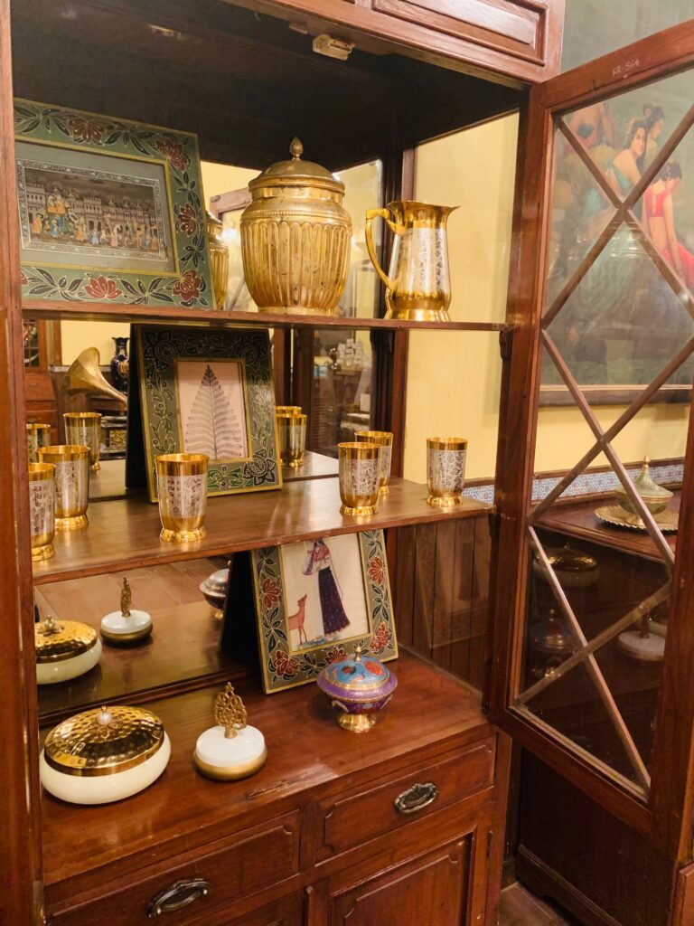 Villa Rashmi - A Heritage Gem in Mumbai | The brass collection and frames at glass display cabinet in the bedroom | TheKeybunch decor blog