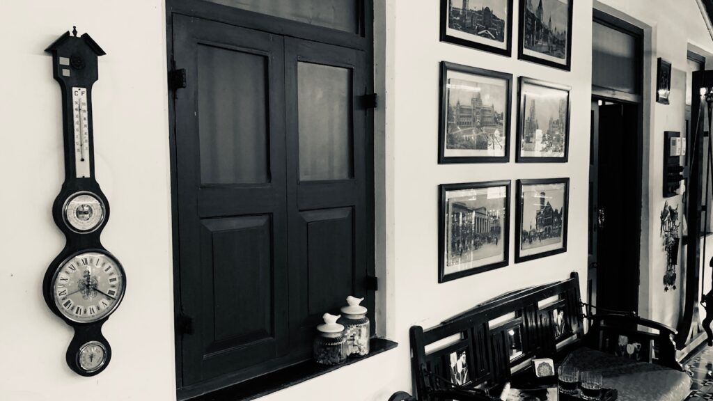 Villa Rashmi - A Heritage Gem in Mumbai | Old antique clock with wall frames in black and white colors | TheKeybunch decor blog