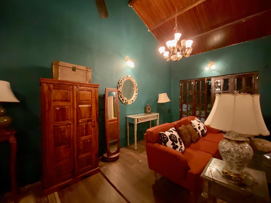 Villa Rashmi - A Heritage Gem in Mumbai | The corner of the room was decorated with decorative mirror frame, wooden cabinet, standing mirror and table lamp | TheKeybunch decor blog