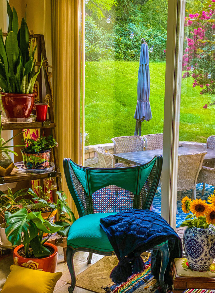 Chitra's Joy-Infused Boho Eclectic home | Antique blue chair with house plants near the window