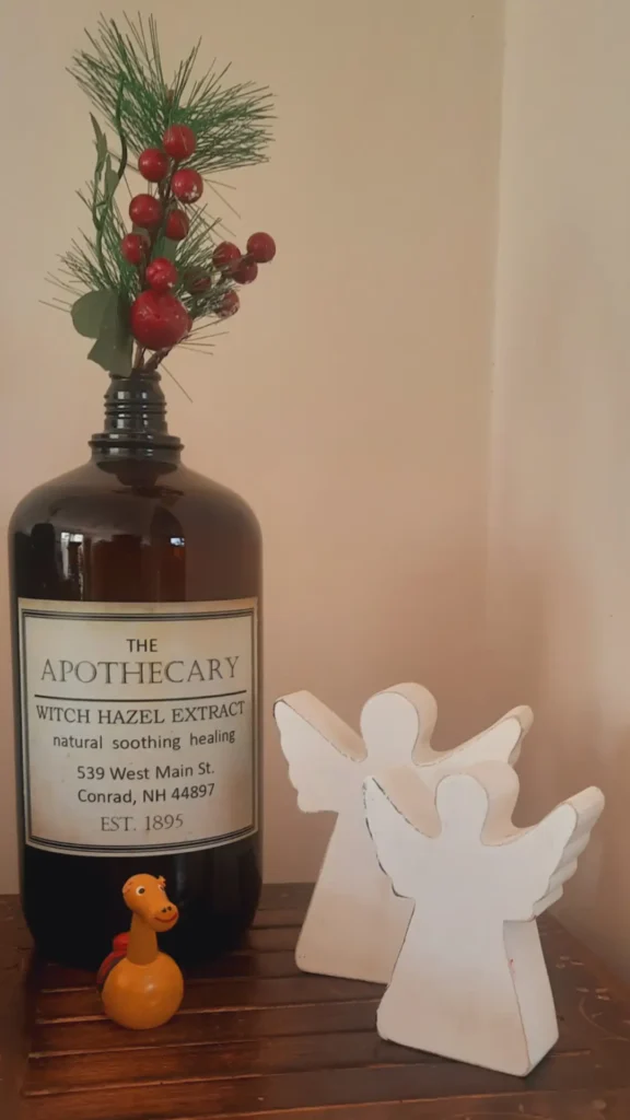Styling tips | Christmas berries in bottle vase with wooden angels at the corner of the room