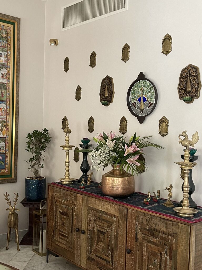 Prameela Nair's Art-Infused Home Abudhabi | Wall decor and indian brass collection at the corner of the living room