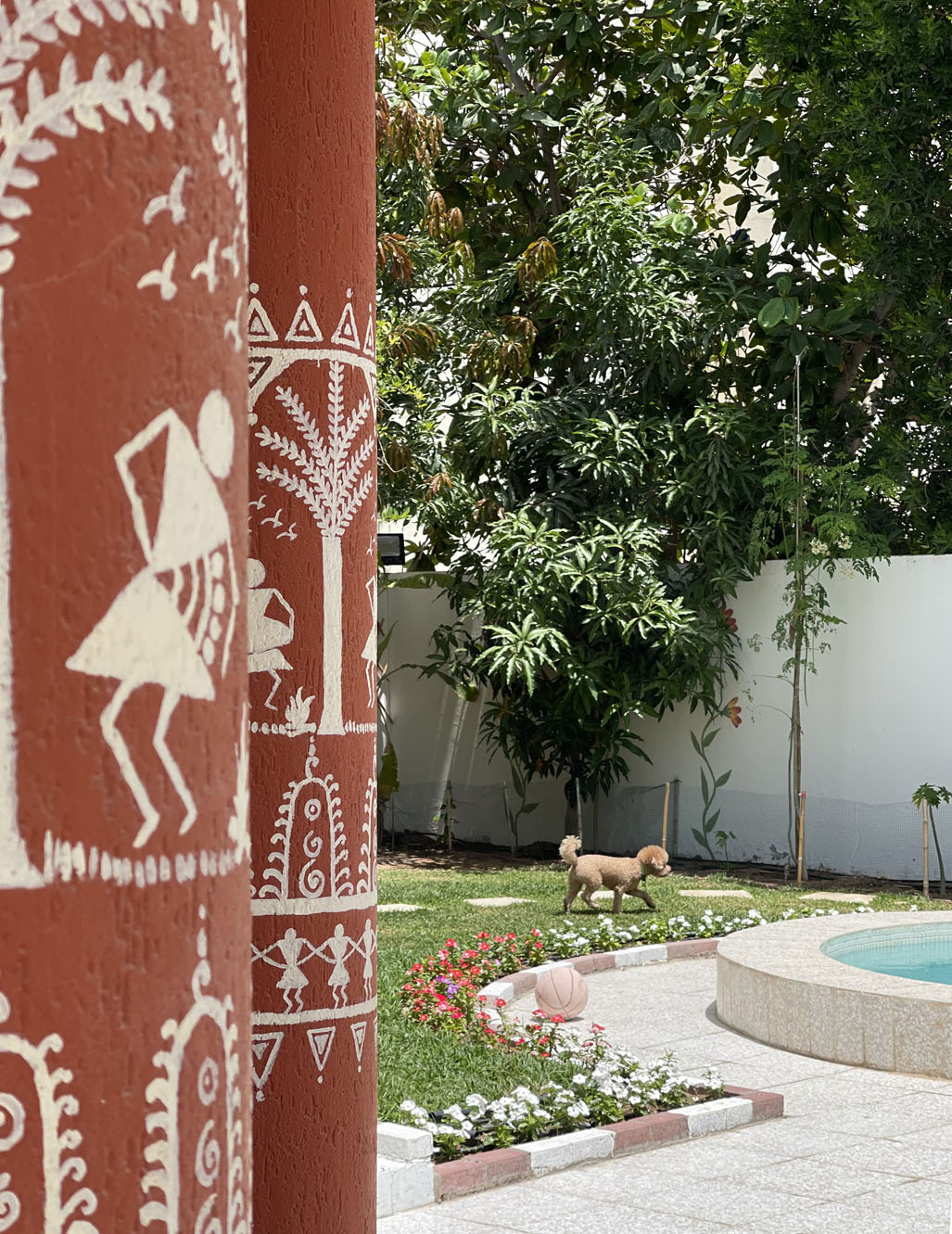 Prameela Nair's Art-Infused Home Abudhabi | Pillar with warli painting on terracotta in green garden