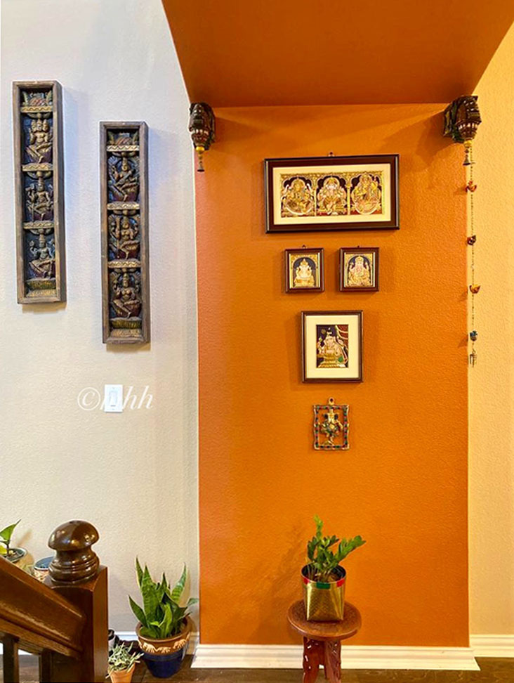 Home tour of Meena Harish | The hallway wall has been decorated with wooden handcraft and tanjore painting 