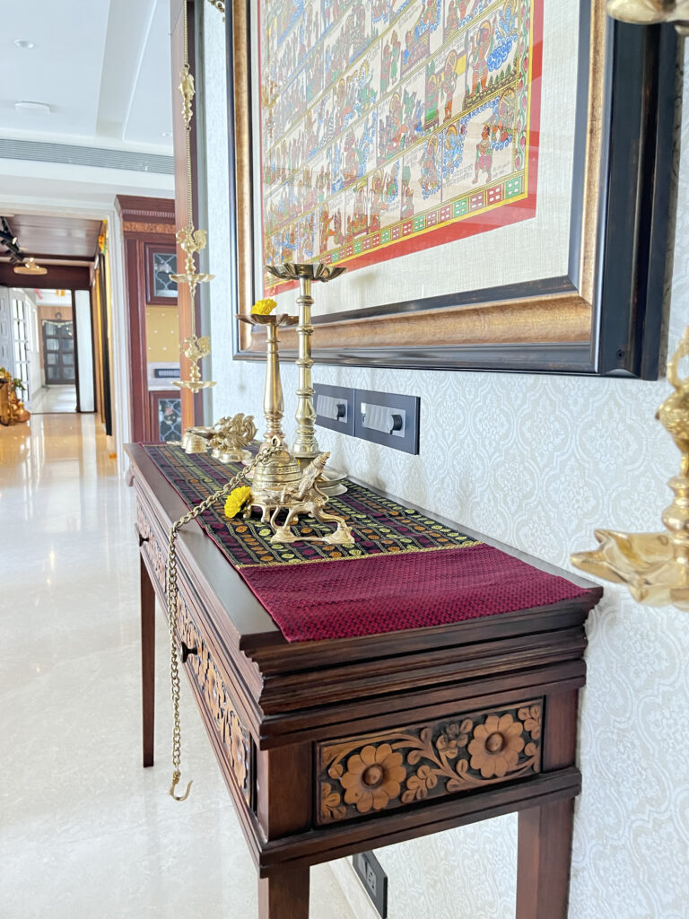 Console table with brass collection and wall art frame | Ranjana and Milind's apartment in Pune