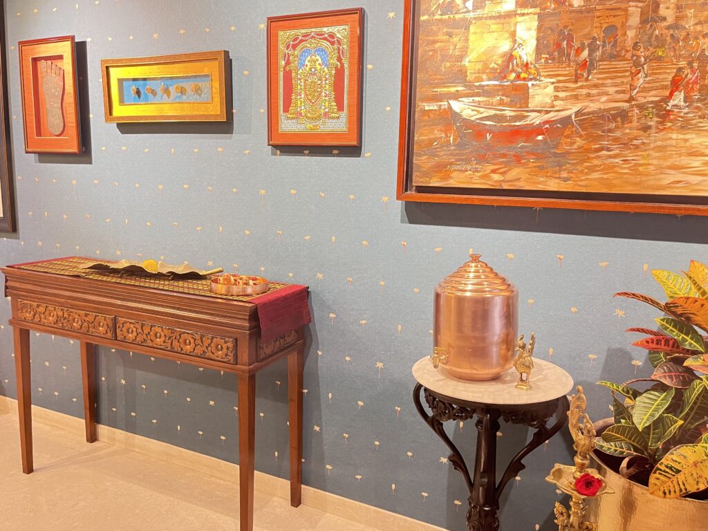 Console table, unique bird diya with brass thali, vintage copper water and the mudras in the entryway gallery wall | Ranjana and Milind's apartment in Pune