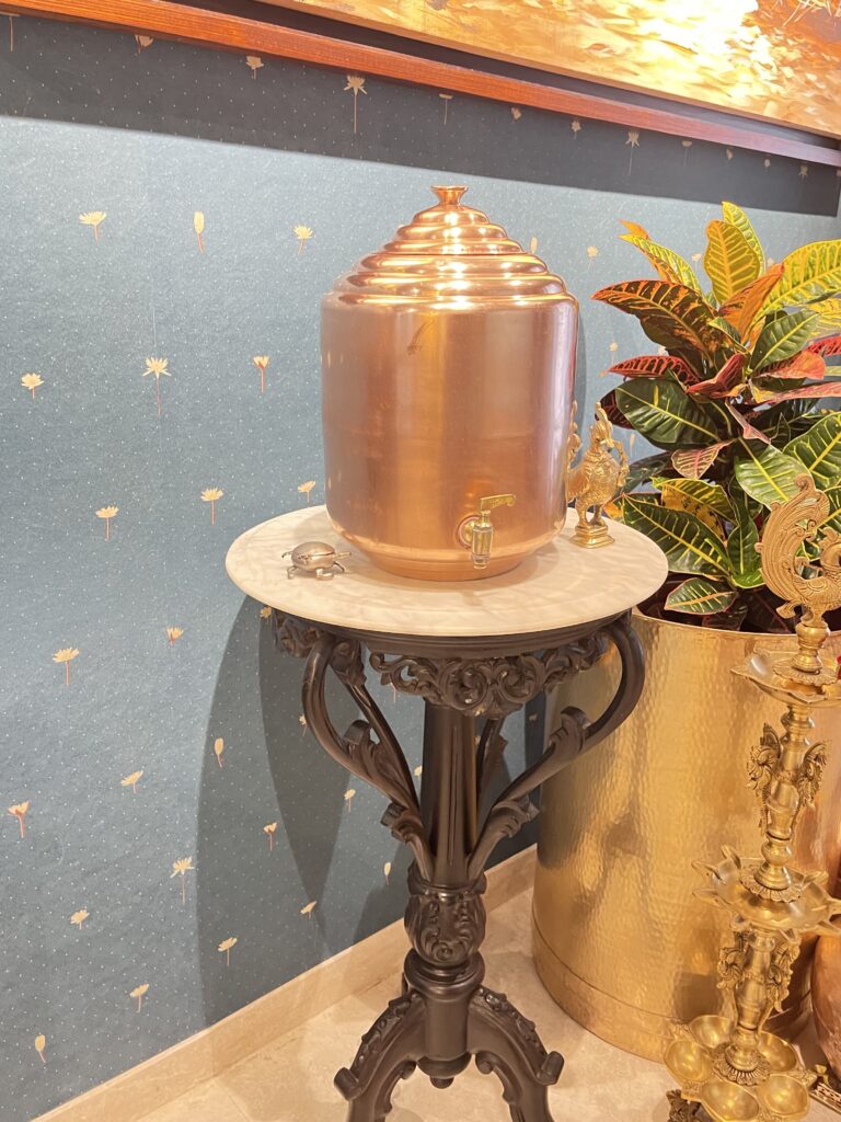 Traditional copper water dispenser at antique side table | Ranjana and Milind's apartment in Pune