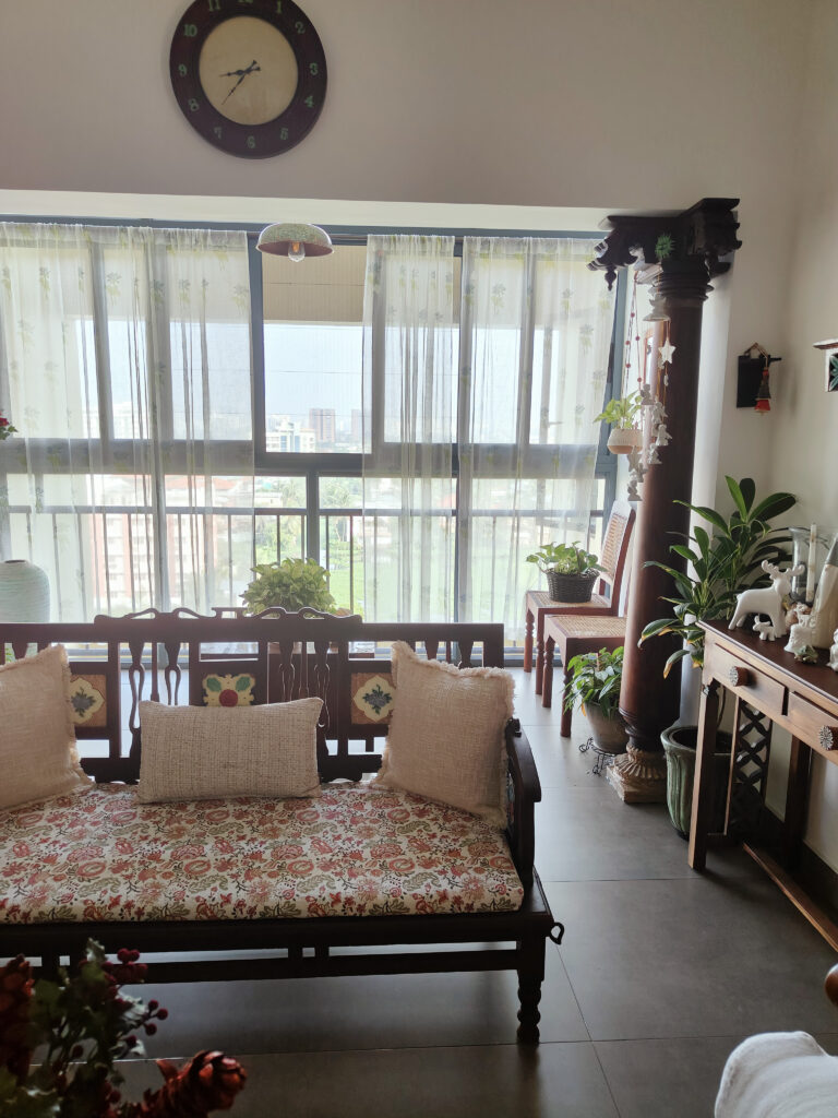 The living room follows the white, green and wood theme and palette | Girija home tour in Kochi