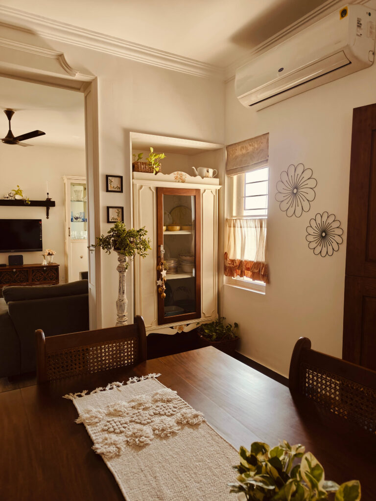 Candle holder with green plants and a long chest in the dining area | Girija home tour in Kochi