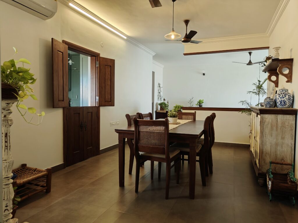 A six-seater teakwood dining table with chairs in cane and wood takes centre stage in the dining area | Girija home tour in Kochi